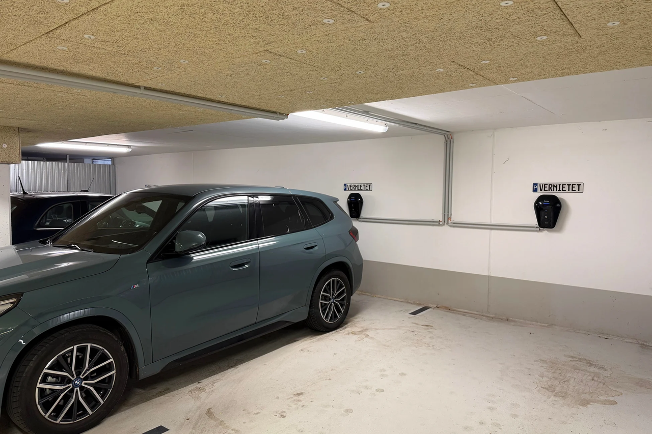 Elektrofahrzeug in einer Tiefgarage mit Wandladestation (Wallbox) und installierter Ladeinfrastruktur für E-Mobilität